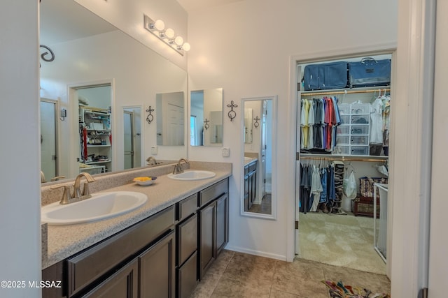 1104 W Pastora Peak Dr, Green Valley, AZ 85614 - bathroom featuring a spacious closet, double vanity, tile patterned flooring, and a stall shower