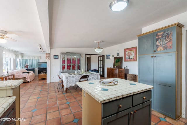 2621 W Rapallo Way, Tucson, AZ 85741 - kitchen featuring tile counters, open floor plan, ceiling fan, a kitchen island, and light tile patterned floors