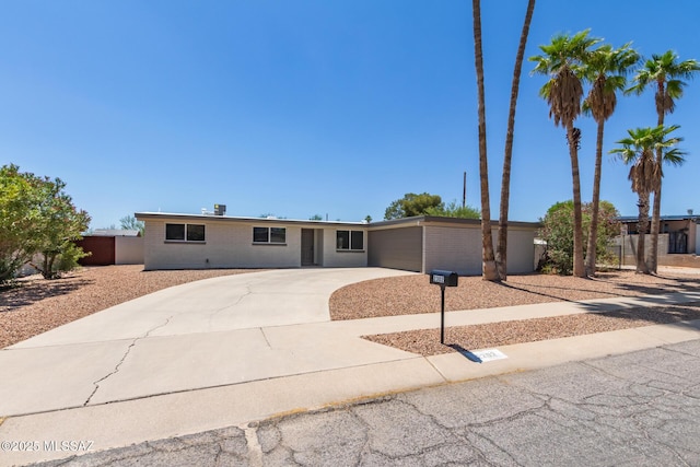 2302 S Cathy Ave, Tucson, AZ 85710 - view of front of property featuring driveway, an attached garage, and brick siding