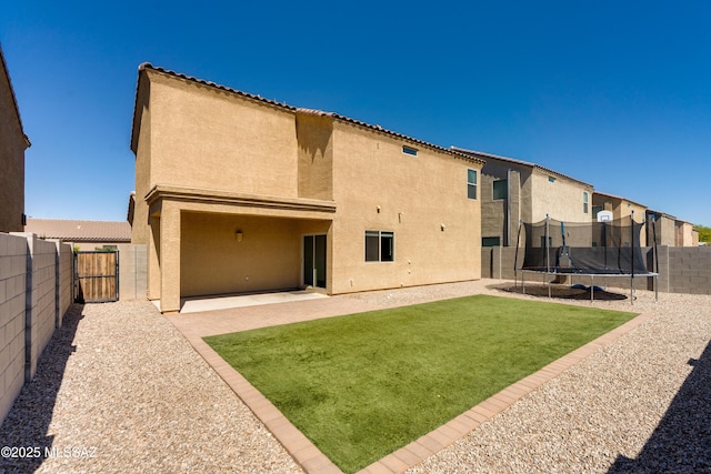 8045 S Red Sox Rd, Tucson, AZ 85756 - back of house with a trampoline and stucco siding