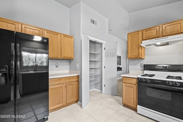 8807 S Desert Rainbow Dr, Tucson, AZ 85747 - kitchen featuring range with gas cooktop, black fridge with ice dispenser, under cabinet range hood, light countertops, and light tile patterned floors