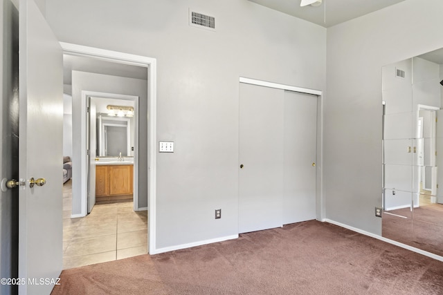 8807 S Desert Rainbow Dr, Tucson, AZ 85747 - unfurnished bedroom featuring light colored carpet, a closet, baseboards, and a sink