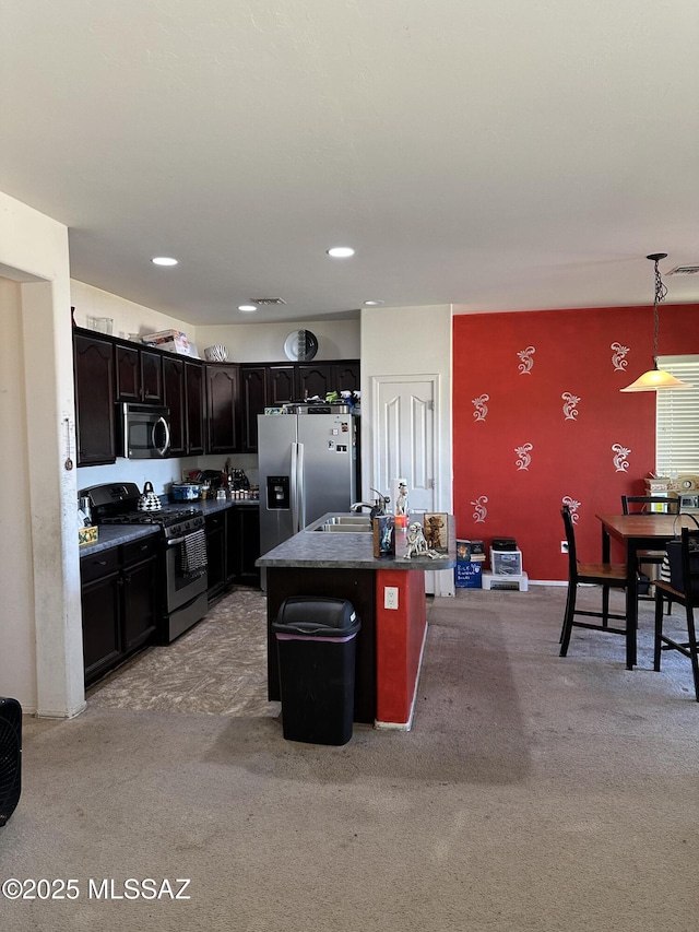 1027 E Madera Grove Ln, Sahuarita, AZ 85629 - kitchen featuring appliances with stainless steel finishes, a kitchen island, light carpet, hanging light fixtures, and recessed lighting