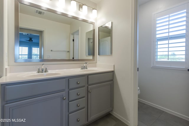 1126 E Cairn St, Tucson, AZ 85719 - bathroom featuring double vanity, baseboards, tile patterned flooring, and toilet