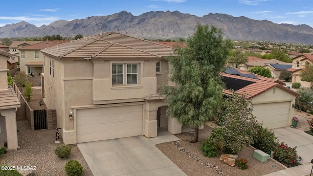 view of front of property with concrete driveway, stucco siding, a tiled roof, and a mountain view