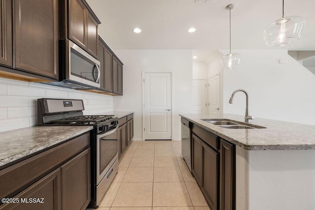 14259 E Yellow Sage Ln, Vail, AZ 85641 - kitchen with stainless steel appliances, a sink, tasteful backsplash, dark brown cabinetry, and light tile patterned floors