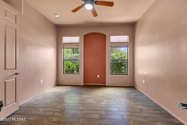 110 Post Way, Tubac, AZ 85646 - spare room with healthy amount of natural light, a ceiling fan, dark wood-style flooring, and arched walkways
