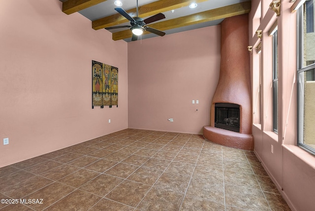 110 Post Way, Tubac, AZ 85646 - unfurnished living room with beam ceiling, ceiling fan, and a large fireplace