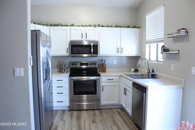 7747 S Lions Spring Way, Tucson, AZ 85747 - kitchen with appliances with stainless steel finishes, a sink, healthy amount of natural light, and light wood-style floors
