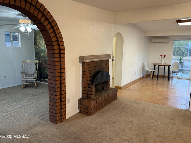 4910 N Gold Ave, Tucson, AZ 85705 - carpeted living area with a wall mounted AC, a ceiling fan, tile patterned flooring, arched walkways, and baseboards