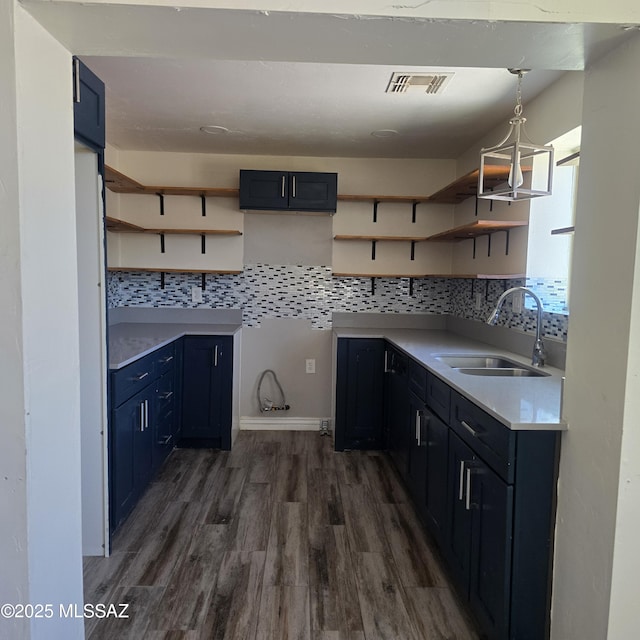 5850 E Lee St, Tucson, AZ 85712 - kitchen featuring a sink, open shelves, dark wood-type flooring, tasteful backsplash, and light countertops