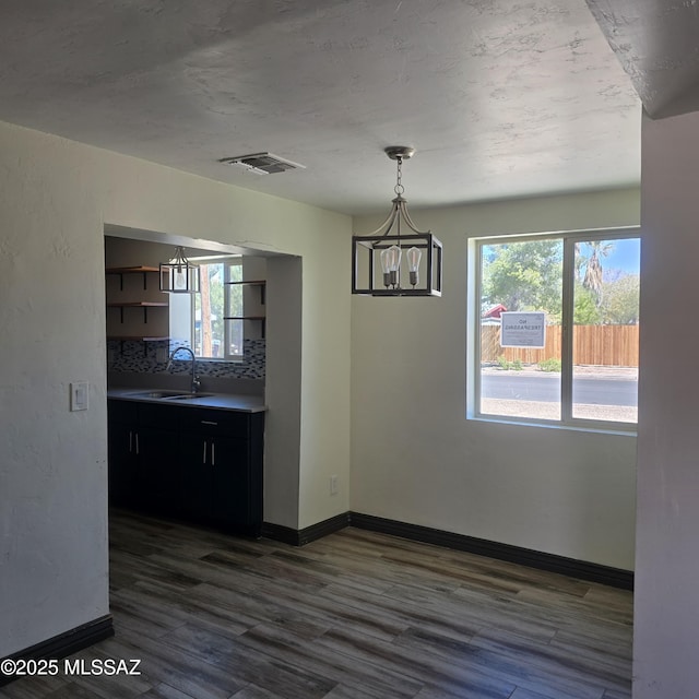 5850 E Lee St, Tucson, AZ 85712 - unfurnished dining area with a sink, a chandelier, plenty of natural light, and dark wood-style floors