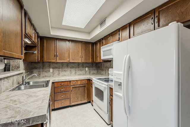 140 W Calle Melendrez, Green Valley, AZ 85614 - kitchen featuring white appliances, a sink, light tile patterned flooring, tasteful backsplash, and tile counters