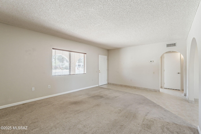 140 W Calle Melendrez, Green Valley, AZ 85614 - spare room with arched walkways, light carpet, a textured ceiling, and baseboards