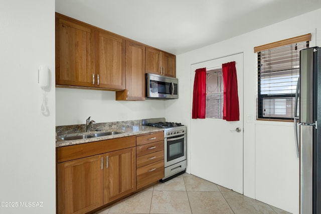 135 S Paseo Quinta Unit D, Green Valley, AZ 85614 - kitchen featuring appliances with stainless steel finishes, a sink, brown cabinetry, and light tile patterned floors