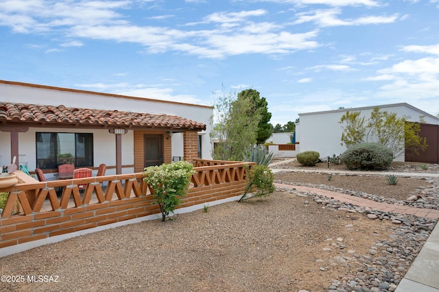 135 S Paseo Quinta Unit D, Green Valley, AZ 85614 - view of home's exterior featuring stucco siding, a porch, and a tiled roof