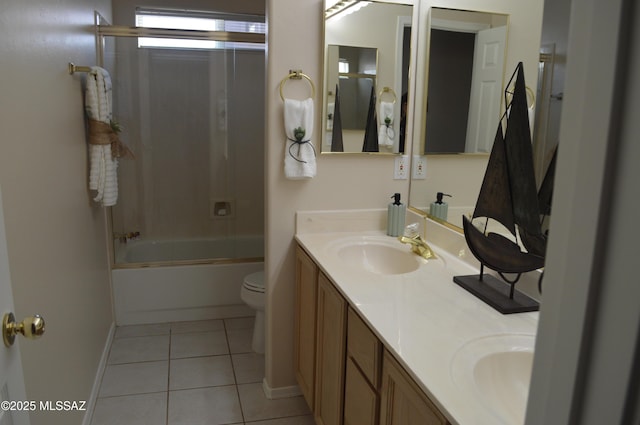 1645 E Ganymede Dr, Tucson, AZ 85737 - bathroom with tile patterned floors, double vanity, toilet, baseboards, and shower / bath combination with glass door