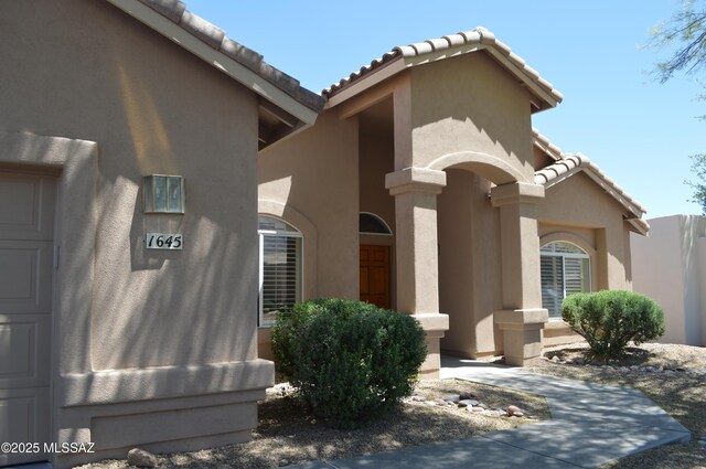1645 E Ganymede Dr, Tucson, AZ 85737 - property entrance with stucco siding and a tile roof
