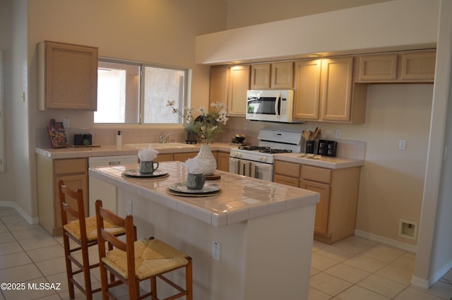 1645 E Ganymede Dr, Tucson, AZ 85737 - kitchen with white appliances, tile countertops, light tile patterned floors, and a high ceiling