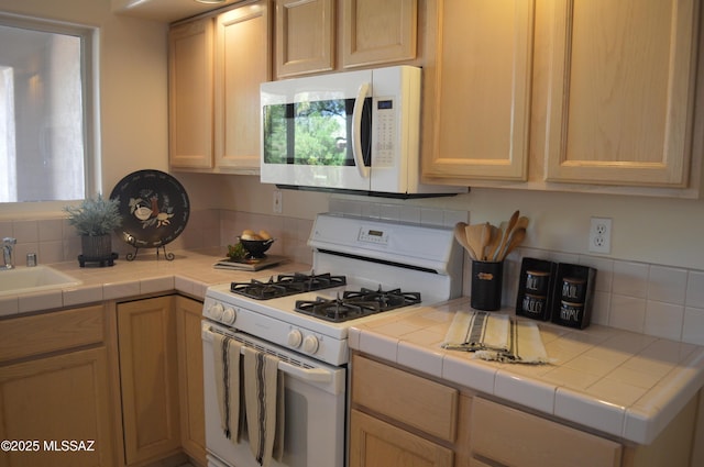 1645 E Ganymede Dr, Tucson, AZ 85737 - kitchen with white appliances, backsplash, a sink, tile counters, and light brown cabinets