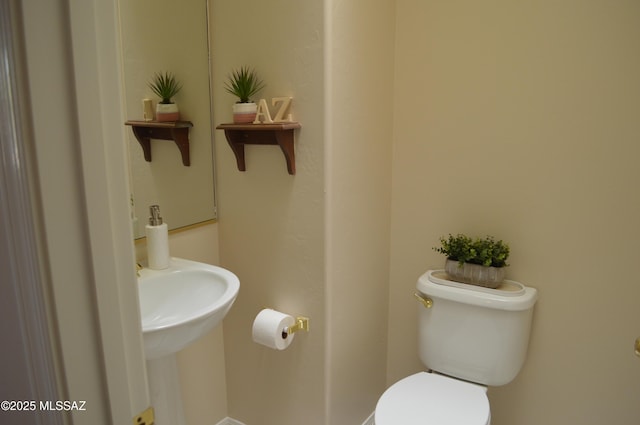 1645 E Ganymede Dr, Tucson, AZ 85737 - bathroom featuring toilet, a sink, and baseboards