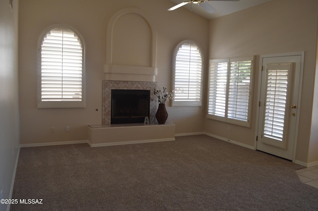 1645 E Ganymede Dr, Tucson, AZ 85737 - unfurnished living room with ceiling fan, a tile fireplace, carpet floors, and baseboards