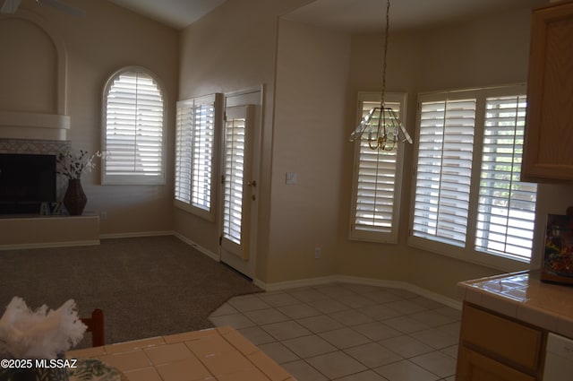 1645 E Ganymede Dr, Tucson, AZ 85737 - unfurnished living room with a chandelier, a tiled fireplace, and baseboards