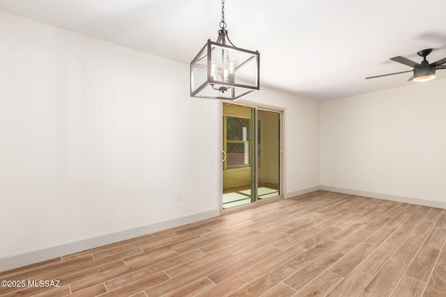 1200 S Alpine Cir, Green Valley, AZ 85614 - unfurnished room with light wood-style floors, baseboards, a chandelier, and ceiling fan