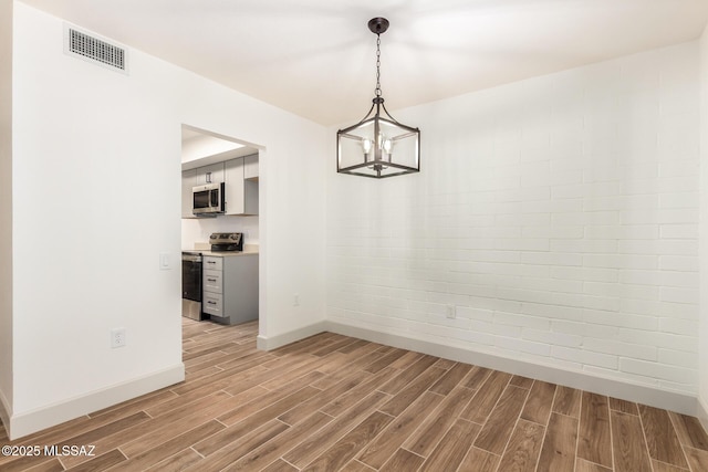 1200 S Alpine Cir, Green Valley, AZ 85614 - unfurnished dining area featuring light wood-style flooring, baseboards, and a chandelier