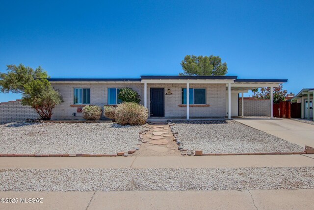 9570 E Sellarole Rd, Tucson, AZ 85730 - single story home featuring concrete driveway, a carport, fence, and brick siding