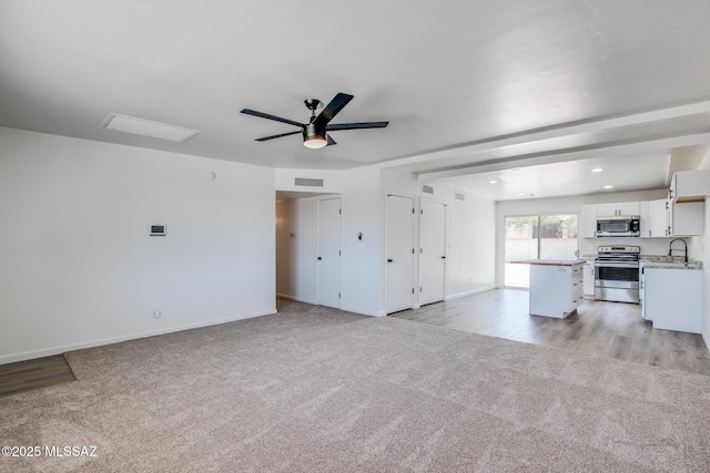 9570 E Sellarole Rd, Tucson, AZ 85730 - unfurnished living room with light carpet, a ceiling fan, baseboards, recessed lighting, and a sink