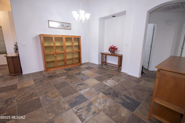 4416 N Saddle View Dr, Tucson, AZ 85750 - dining area with stone tile flooring, arched walkways, and a chandelier