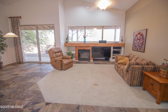 4416 N Saddle View Dr, Tucson, AZ 85750 - living area with high vaulted ceiling, a tiled fireplace, ceiling fan, and stone finish floors