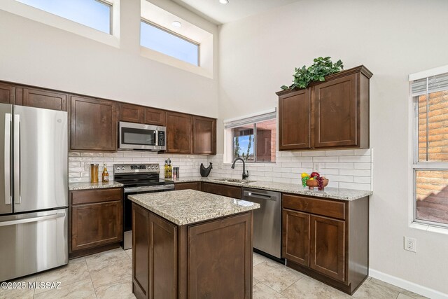 2742 S Via Del Bac, Green Valley, AZ 85622 - kitchen with stainless steel appliances, a sink, a towering ceiling, backsplash, and dark brown cabinetry