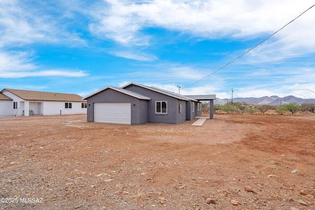 1846 Gardenias Ct, Rio Rico, AZ 85648 - rear view of house with an attached garage, stucco siding, a mountain view, and driveway