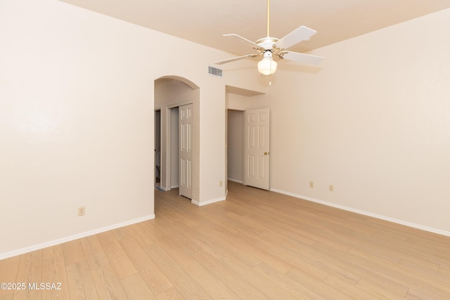 11629 N Copper Creek Dr, Oro Valley, AZ 85737 - unfurnished room with arched walkways, light wood finished floors, a ceiling fan, and baseboards