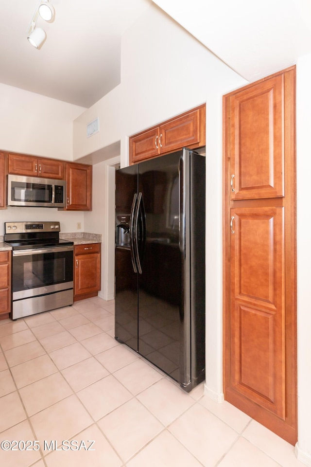 11629 N Copper Creek Dr, Oro Valley, AZ 85737 - kitchen with appliances with stainless steel finishes, light countertops, light tile patterned floors, and brown cabinetry