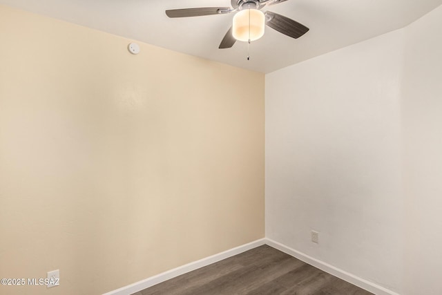 unfurnished room with dark wood-style flooring, a ceiling fan, baseboards, and a smoke detector