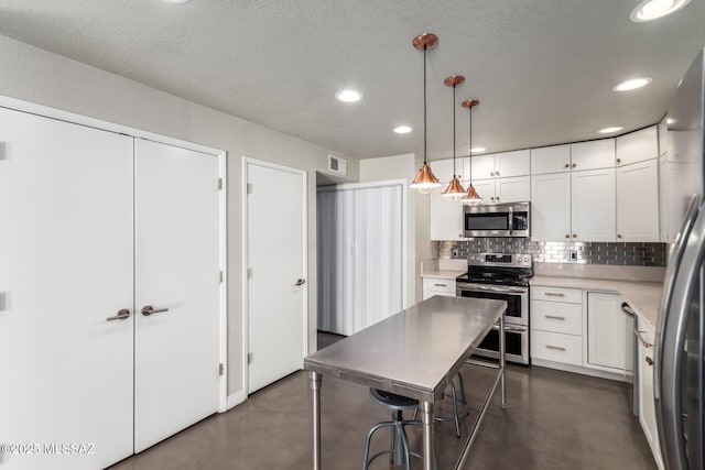 kitchen featuring stainless steel appliances, concrete floors, backsplash, white cabinets, and recessed lighting