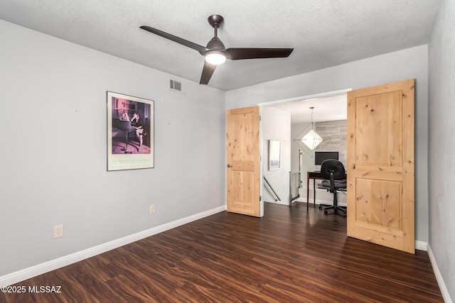 unfurnished room with dark wood-type flooring, a ceiling fan, baseboards, and an office area