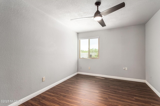 spare room with dark wood finished floors, ceiling fan, baseboards, and a textured ceiling