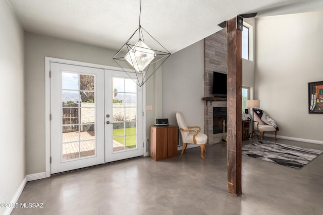 entryway featuring french doors, plenty of natural light, a fireplace, and baseboards