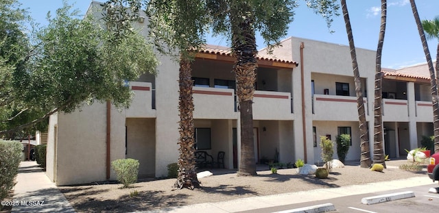 455 W Kelso St Apt 232, Tucson, AZ 85705 - view of front facade with stucco siding, uncovered parking, and a tiled roof