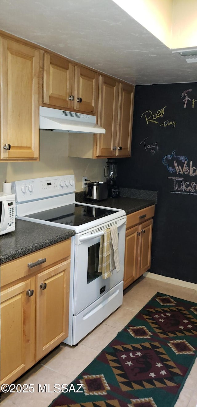 455 W Kelso St Apt 232, Tucson, AZ 85705 - kitchen with white appliances, under cabinet range hood, light tile patterned flooring, and dark countertops