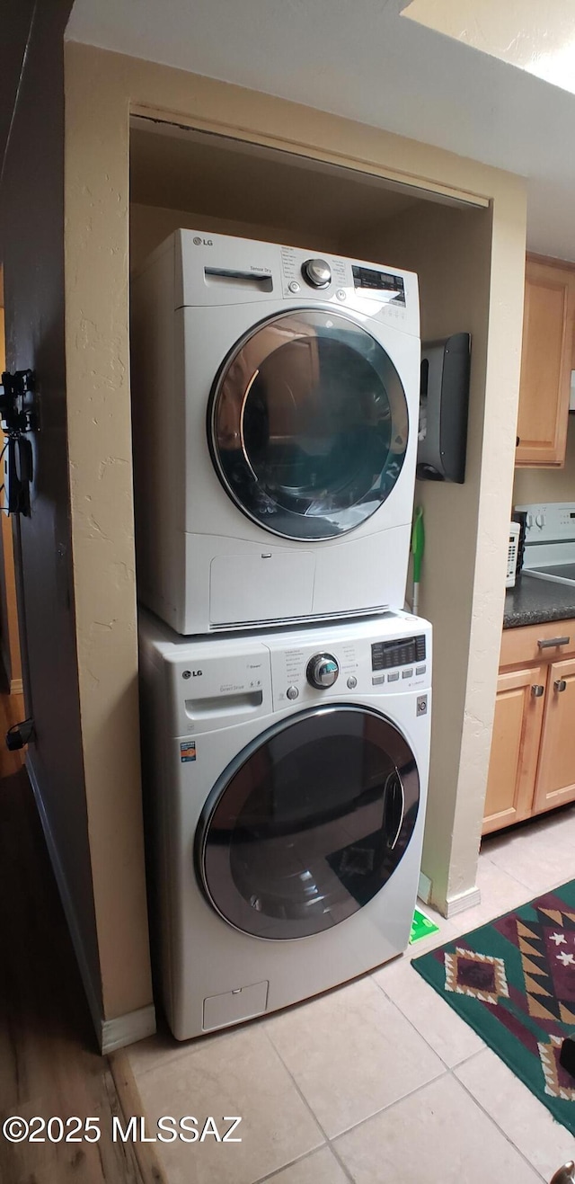 455 W Kelso St Apt 232, Tucson, AZ 85705 - laundry area with stacked washing machine and dryer and light tile patterned floors