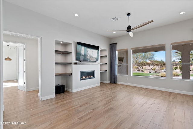 31566 S Misty Basin Rd, Oracle, AZ 85623 - unfurnished living room with ceiling fan, light wood-type flooring, a glass covered fireplace, recessed lighting, and baseboards