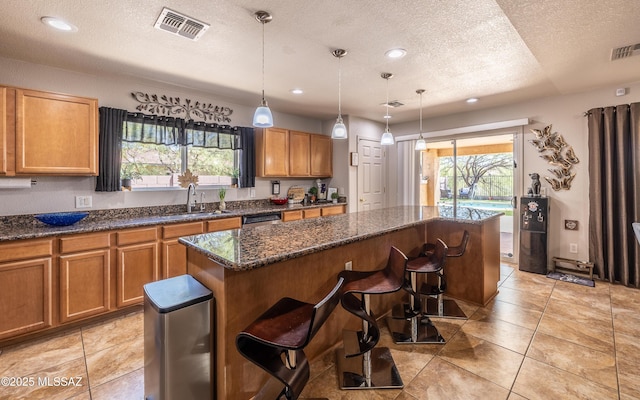 13570 E Hampden Green Way, Vail, AZ 85641 - kitchen with a sink, a center island, a textured ceiling, plenty of natural light, and a breakfast bar area
