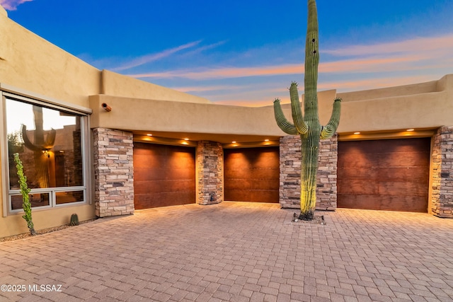 545 E Thunderstorm Pl, Oro Valley, AZ 85755 - view of front of house with stucco siding, a garage, and decorative driveway
