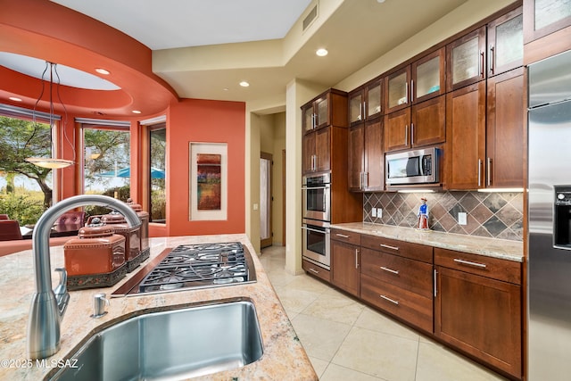 545 E Thunderstorm Pl, Oro Valley, AZ 85755 - kitchen featuring appliances with stainless steel finishes, backsplash, recessed lighting, light stone counters, and glass insert cabinets