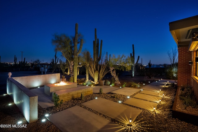 4535 N Caminito Callado, Tucson, AZ 85718 - yard at night with an outdoor fire pit and a patio area
